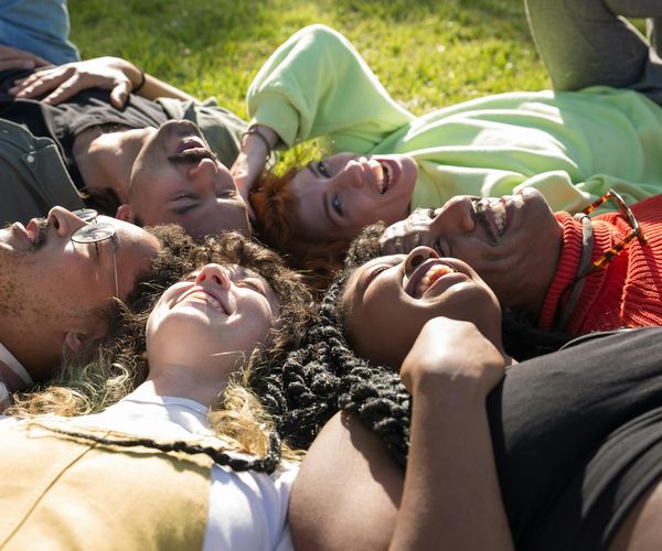 Group of diverse people smiling and relaxing after a yoga session.